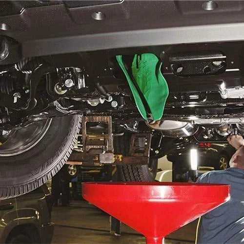 Using the flexible funnel under a car to drain oil