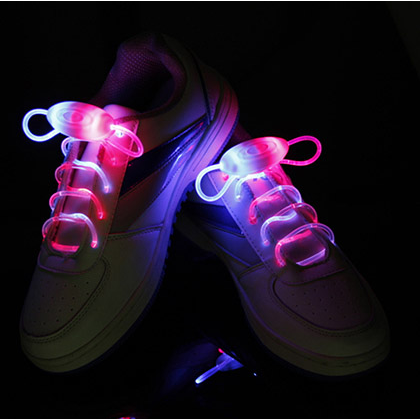 White sneakers glowing with blue and pink LED shoelaces