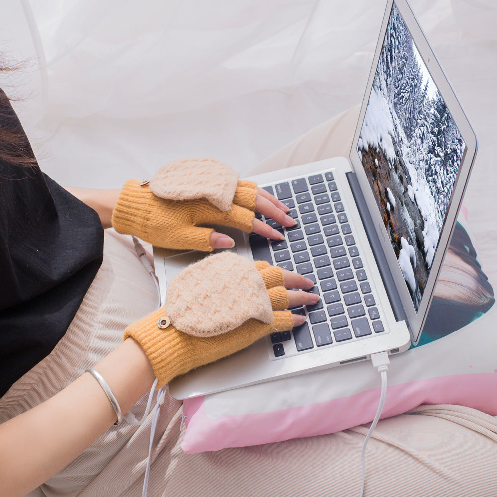 Person typing on a laptop wearing yellow heated gloves