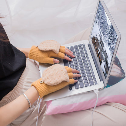 Person typing on a laptop wearing yellow heated gloves
