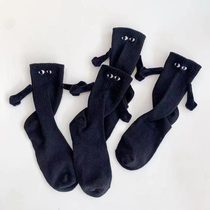 Two pairs of black magnetic socks holding hands