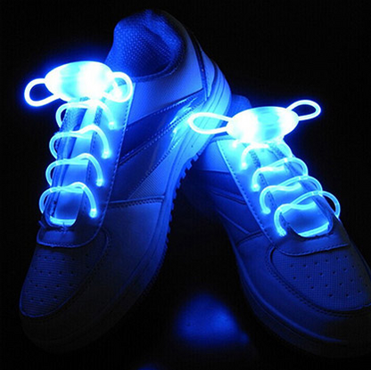 White sneakers glowing with bright blue LED shoelaces