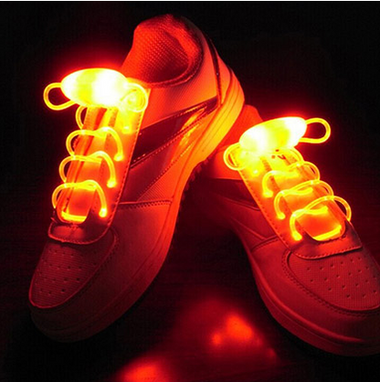 White sneakers glowing with bright red LED shoelaces