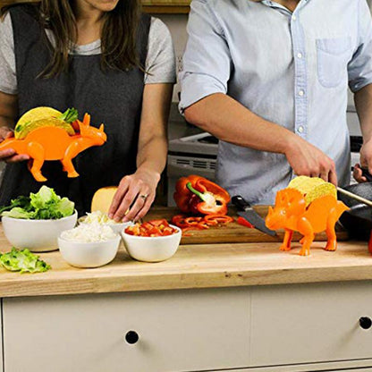 People preparing tacos using orange dinosaur taco holders in a kitchen