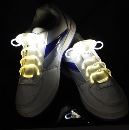 White sneakers glowing with white LED shoelaces
