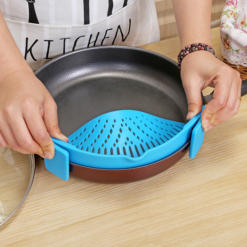 Blue silicone strainer clipped onto a pan