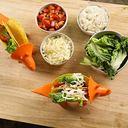 Overhead view of two orange dinosaur taco holders filled with food