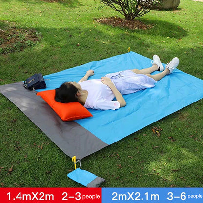 People resting on a blue picnic blanket