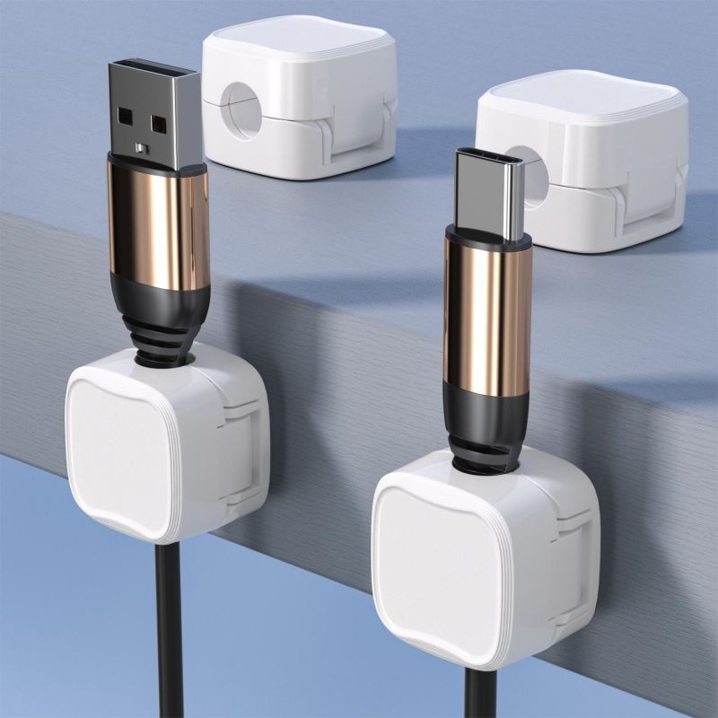 White magnetic cable organizer clips holding cables securely on a desk edge