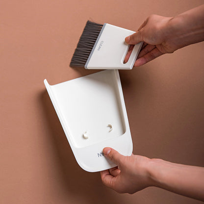 Hands detaching the mini broom from the dustpan