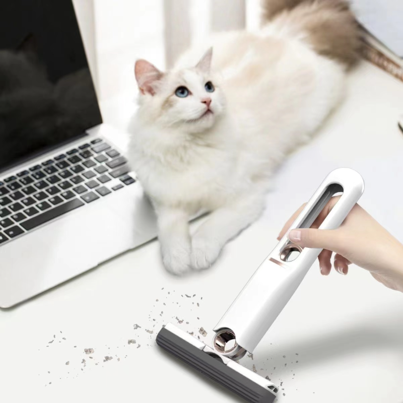 White mini squeeze mop cleaning a white desk next to a cat