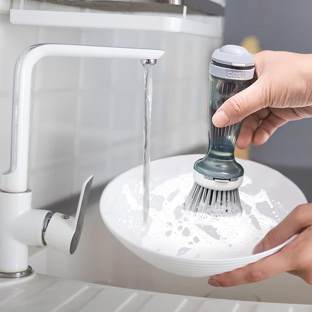 Rinsing the soap dispensing dish brush under a kitchen faucet