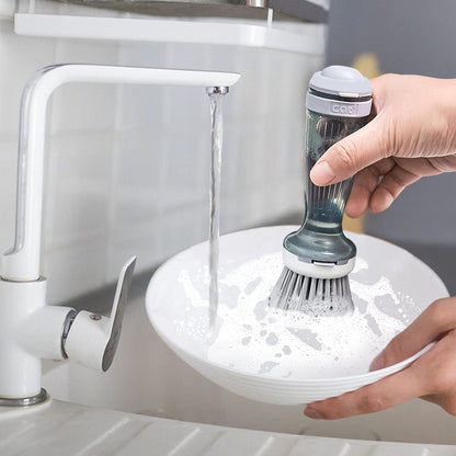 Rinsing the soap dispensing dish brush under a kitchen faucet