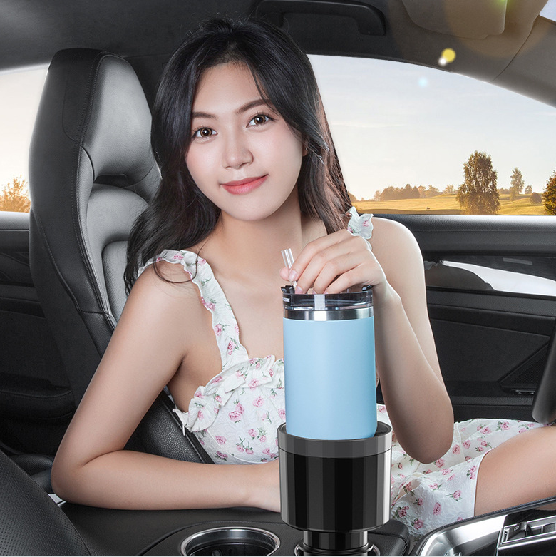 Woman in a car with a large blue cup in the cup holder expander