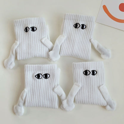 Two pairs of white magnetic socks holding hands