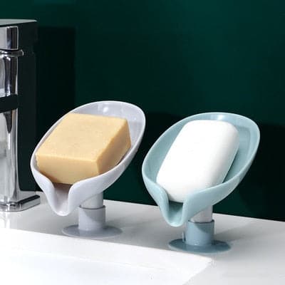 Green leaf shaped self draining soap dish on a bathroom sink