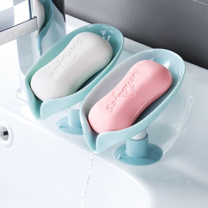 Leaf shaped plastic soap dish holding a cleaning sponge