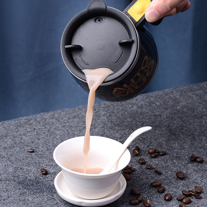 Self-stirring cup resting on a desk next to a laptop