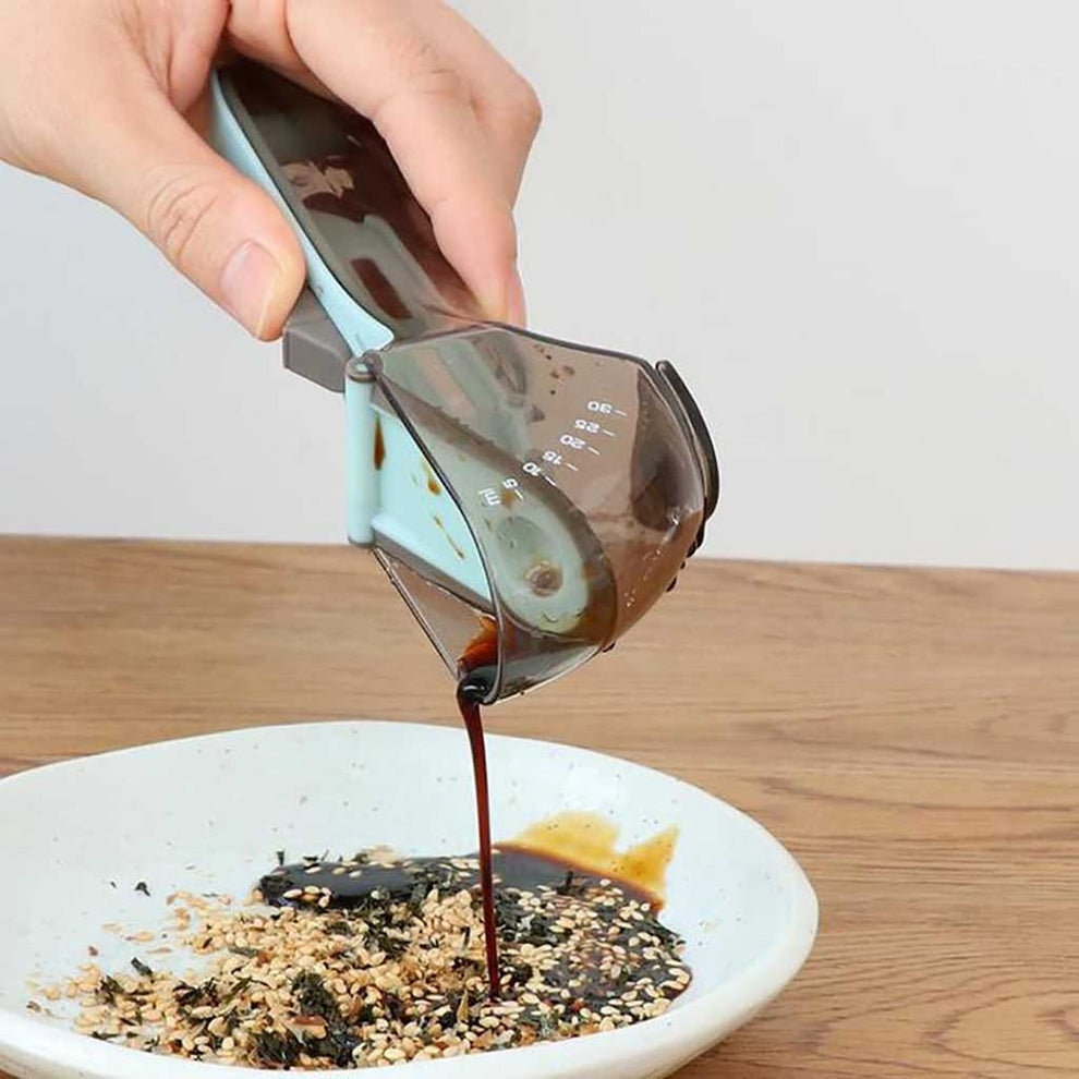 Measuring cup with silicone and metal details on a kitchen table.