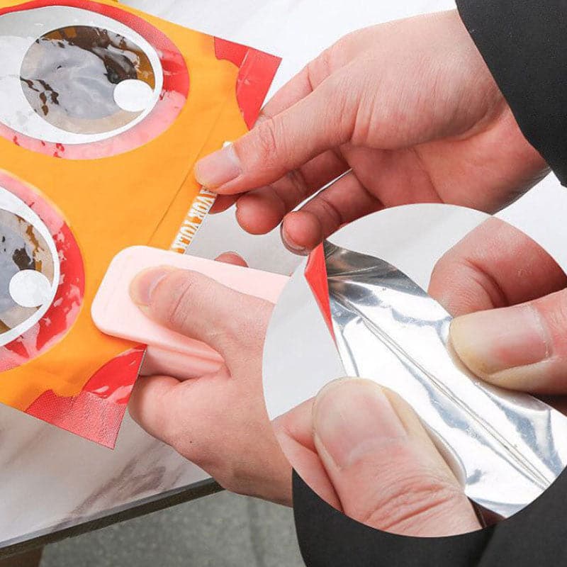 Person sealing a bag of chips with a small kitchen tool