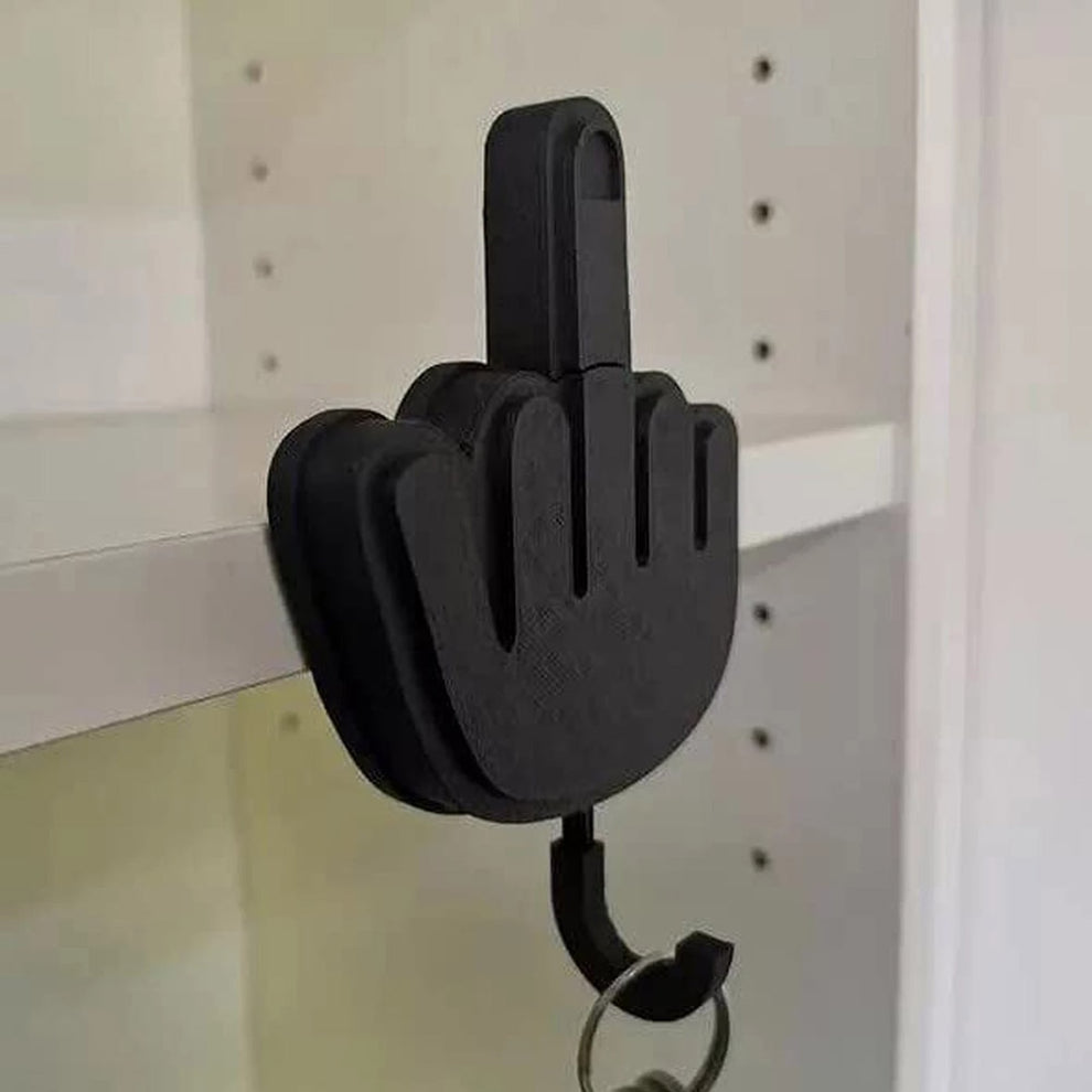 Middle finger shaped wall hook holding a set of keys.